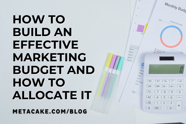 A monthly budget chart, calculator, and markers on a desk for marketing budget allocation best practices.